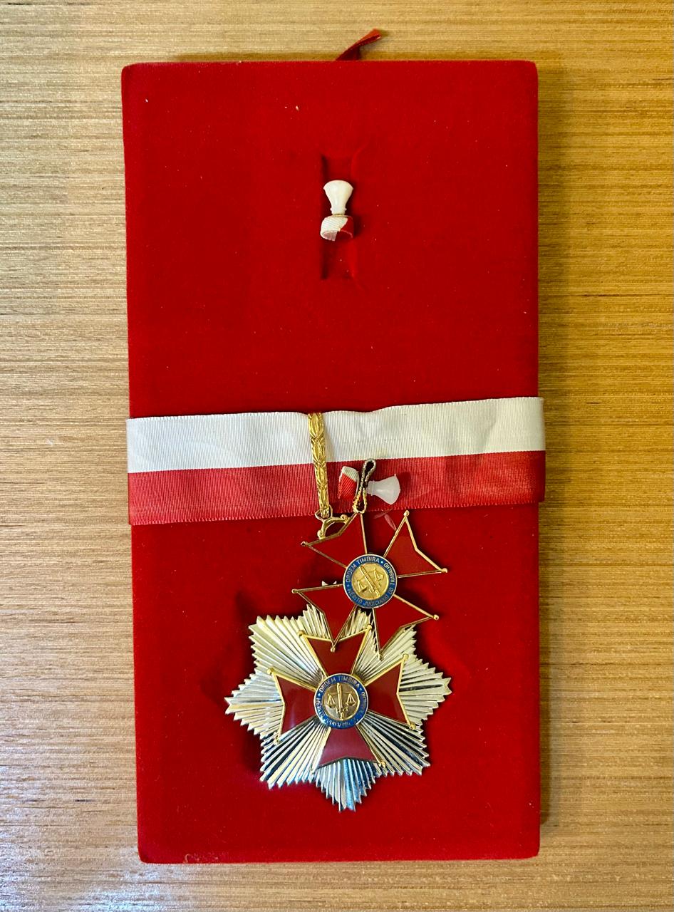 Medalha apoiada em base na cor vermelha