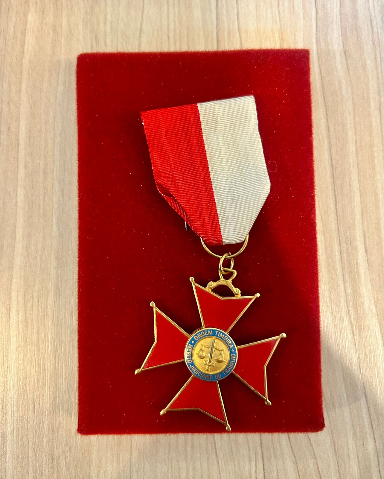 Medalha apoiada em base na cor vermelha