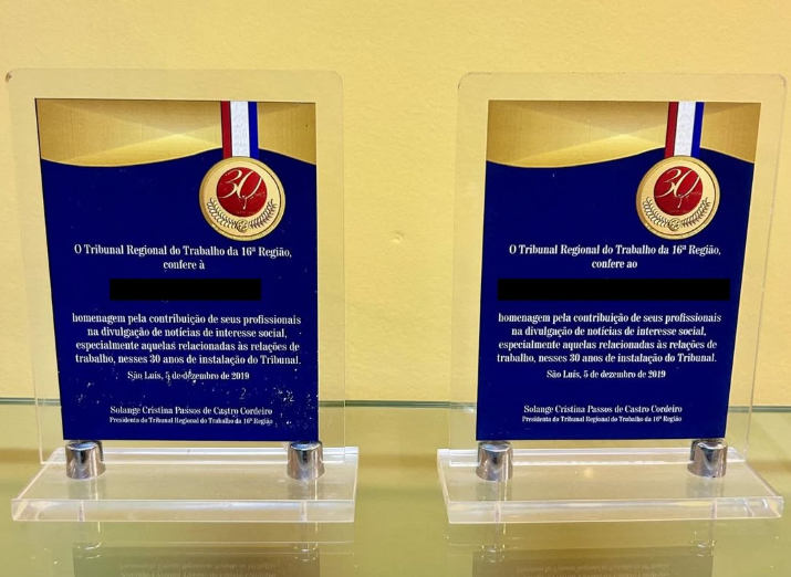 Placas na cor azul, com letras na cor branca, apoiadas em base transparente