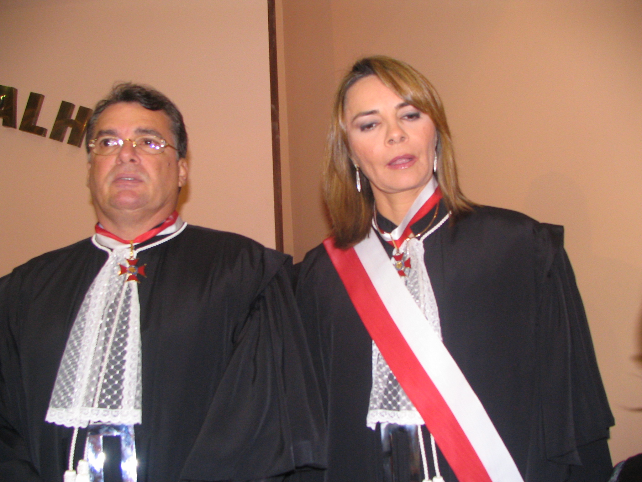 homem de toga ao lado de mulher de toga pousando para foto