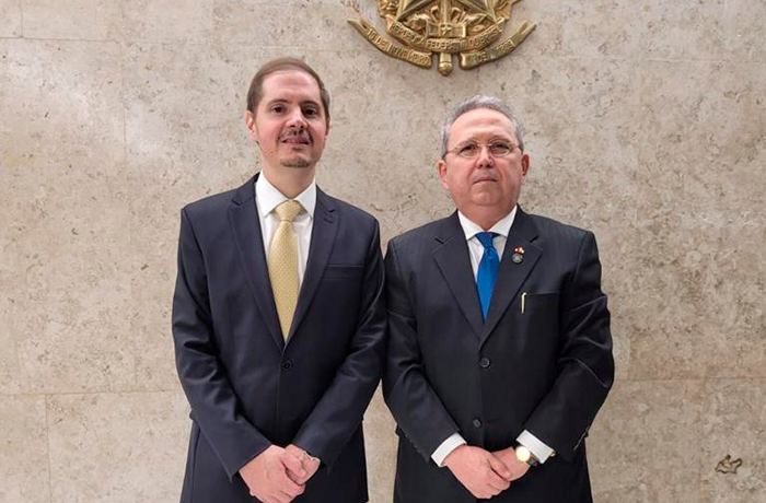 Imagem do advogado-geral da União e do presidente do TRT-16, lado a lado, tendo a fundo parede em tom bege e o brasão dourado da República do Brasil.
