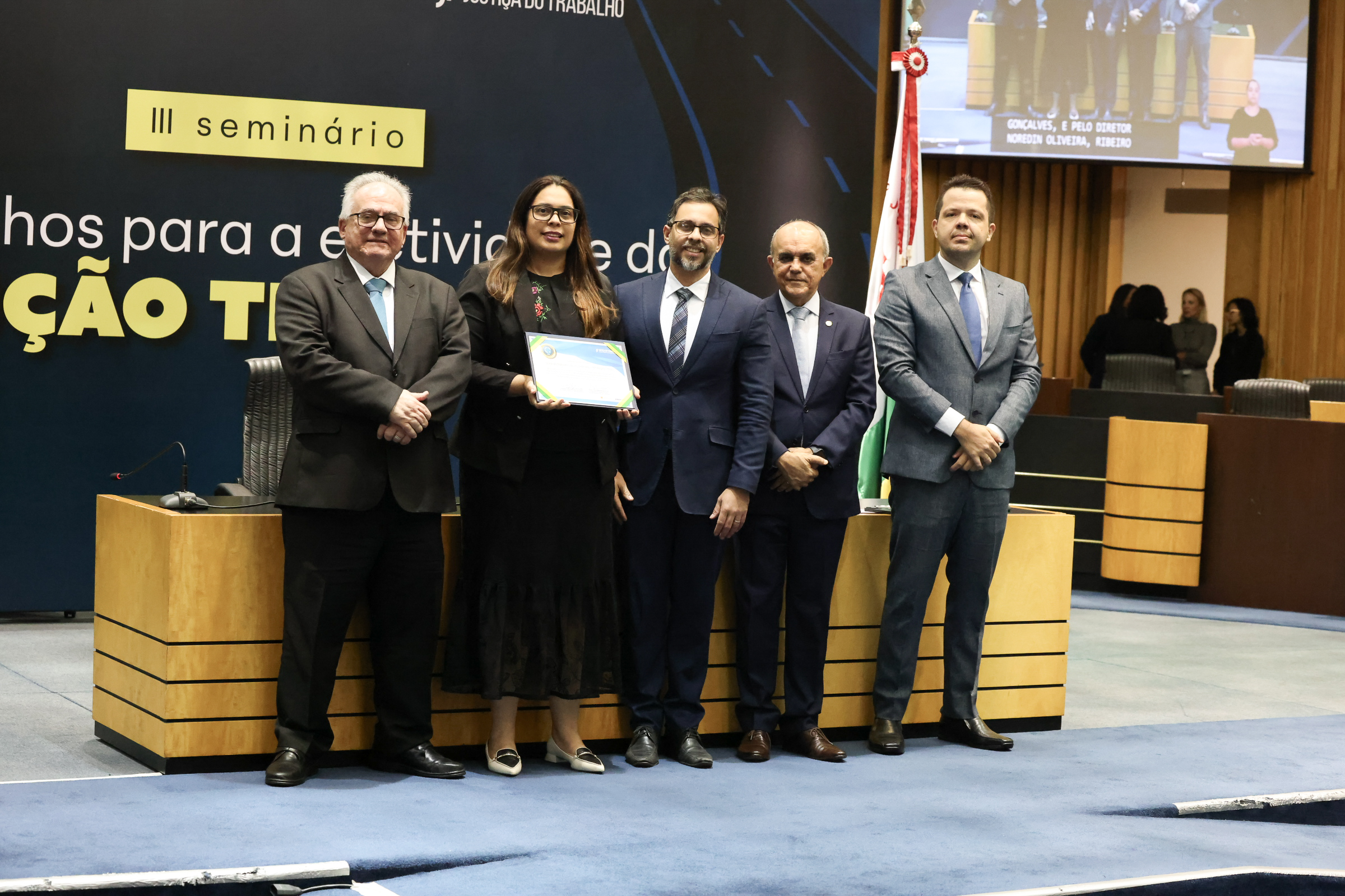Foto mostra a juíza titular, Erika Guimarães Gonçalves e o diretor de secretaria, o servidor Noredim Oliveira Reuter Ribeiro Neto recebendo a certificação das mãos dos ministros do TST Maurício Godinho Delgado e Cláudio Mascarenhas Brandão