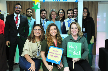 Foto mostra 11 pessoas agrupadas. Algumas seguram placas com mensagens.