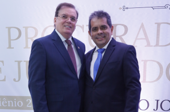 Fto mostra dois homens em pé um ao lado do outro. Ambos usam ternos escuros