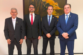 Foto mostra 4 homens usando terno escuro. Ambos estão em pé, um ao lado do outro