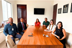 Foto mostra seis pessoas sentados à mesa. São 3 homens e três mulheres