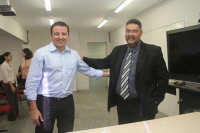Diretor geral, Júlio César Guimarães ( de terno), cumprimenta Henrique Mota, primeiro servidor empossado na tarde