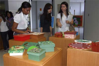 Visitantes apreciam  as peças artesanais, com destaque para as caixinhas em MDF.