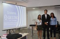 Juiz Bruno Motejunas ladeado pelas servidoras Olívia Almeida e Fabiana Santalúcia