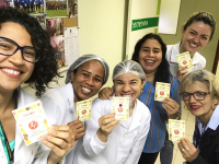 Servidoras, terceirizadas e estagiárias da Seção de Saúde exibem os cardápios distribuídos