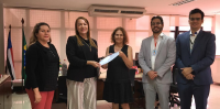 Presidenta Solange, entre Iara, Noredim e Wellington, recebendo o relatório das mãos de Socorro