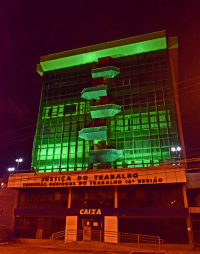 fachada do prédio-sede iluminada de verde durante este mês