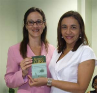Rosely Vieira entrega, à secretária exeuctiva da Escola Judicial, Kamilly Barros,  edição do livro usado no curso de facilitadores