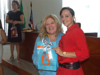 Adriana Albuquerque, uma das sorteadas, recebe o brinde das mãos da desa. Ilka Esdra