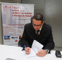 Des. James Magno autografa seu novo livro.