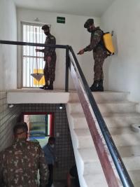 Imagem de militares sanitizando escadas 