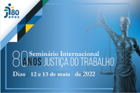 Imagem predominante em azul degradê, ilustração da deusa da justiça à direita, com o texto Seminário Internacional 80 ANOS JUSTIÇA DO TRABALHO, Dias 12 e 13 de maio de 2022. e acima, à esquerda, logo dos 80 anos da JT