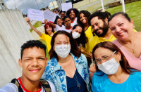 Foto de alunos da Escola Luís Alves Ferreira juntamente com a gestora da Escola, Sandra Torres, que está de máscara branca e blusa azul, atrás dela a juíza Liliana Bouéres, e do outro lado a auditora fiscal do trabalho Léa Cristina da Costa Silva, da Superintendência Regional do Trabalho no Maranhão