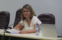 Foto da desembargadora Márcia Andrea, do TRT do Maranhão, cabelos claros, usando óculos, vestindo roupa branca, sentada à mesa, centralizada, no auditório da Escola Judicial, durante abertura da 17ª Semana de Formação de Magistrados