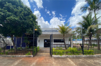 Foto da fachada da Vara do Trabalho de Estreito, no sudoeste do Maranhão, onde se vê no primeiro plano uma cercadura de ferro e algumas plantas e, em segundo plano, a fachada da vara trabalhista onde está escrito, na parte superior: Justiça do Trabalho, Vara do Trabalho de Estreito