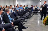 Imagem perpendicular do desembargador que veste terno escuro e fala para a plateia de magistradas e magistrados sentados no auditório da Escola Judicial