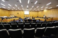 Foto do Pleno do Tribunal Superior do Trabalho, em Brasília, onde se vê quatro bancadas de madeira, das quais duas laterais (maiores) e duas no centro, onde ficam sentados ministros e ministras do TST, servidores, membros do Ministério Público do Trabalho, além de cadeiras onde ficam sentados as partes processuais, advogados e advogadas; as paredes são revestidas de madeira na mesma cor das bancadas; o teto com várias luminárias.