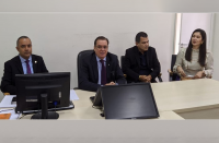 Foto da bancada da sala de audiência da Vara do Trabalho de Caxias, durante a abertura da correição, com a presença do corregedor regional do TRT-16, desembargador Gerson de Oliveira, que está entre os juízes Fábio Sousa (à esquerda) e Higino Galvão, que estão de terno escuro, sentados, e da presidente da Subseção da OAB de Caxias, Amanda Mesquita, que está usando blusa bege