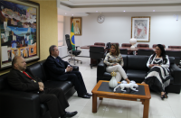 Foto dos participantes da visita sentados em sofás pretos, conversando.