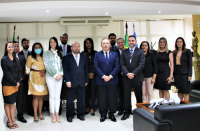 Foto do presidente do TRT, desembargador Carvalho Neto (vestindo blazer azul, calça preta e gravata azul), do juiz Saulo Fontes (usando paletó azul marinho e gravata listrada de cinza e branco), ladeados pelas servidoras e servidores empossados, no Gabinete da Presidência.