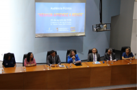 Foto de pessoas sentadas à mesa de honra no auditório onde foi realizado o evento