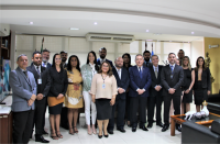 Foto do presidente do TRT, desembargador Carvalho Neto (vestindo blazer azul, calça preta e gravata azul), do juiz Saulo Fontes (usando paletó azul marinho e gravata listrada de cinza e branco), ladeados pelas servidoras e servidores empossados, no Gabinete da Presidência, e por outros gestores do Tribunal..