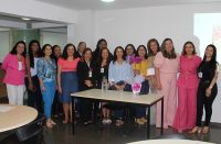 Fotos de várias mulheres que estão em pé, em um salão e próximas a uma mesa