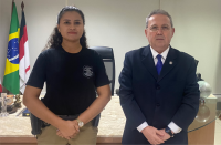 foto de uma mulher com fardamento policial ao lado de homem com terno escuro 