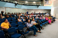 Foto de várias pessoas (mulheres e homens) em um auditório