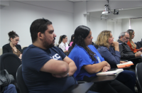 Fotos de mulheres e homens sentados em cadeiras num auditório