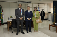 Três pessoas em pé posando para a foto dentro de um gabinete, sendo dois homens e uma mulher. 