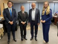 Quatro pessoas posam para foto dentro de um gabinete. Todos estão vestidos formalmente.