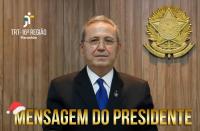 Foto de um homem posando para a câmera, usando terno e óculos de grau. Texto escrito MENSAGEM DO PRESIDENTE na parte inferior.