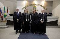 Quatro pessoas posam para foto dentro de um plenário, dois homens e duas mulheres. As mulheres estão centralizadas.