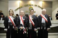 Quatro pessoas posam para foto dentro de um plenário, dois homens e duas mulheres. Todos vestidos com toga.