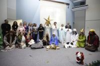 Foto da encenação do auto de natal dentro de um auditório.