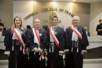 Quatro pessoas posam para foto dentro de um plenário, dois homens e duas mulheres. Todos vestidos com toga.