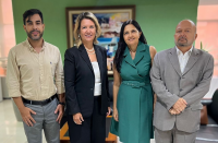 Quatro pessoas posando para foto dentro de um gabinete. Duas mulheres ao centro e dois homens.