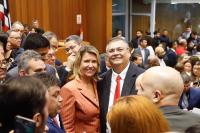 Duas pessoas posando para a foto dentro de um auditório. 