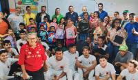 Grupo de pessoas posando para uma foto dentro de uma sala de aula.