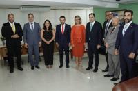 Grupo de pessoas posando para foto dentro de uma sala.