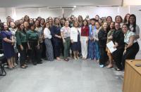 Grupo de mulheres posando para foto dentro de uma sala.