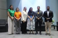Seis pessoas posando para foto dentro de um auditório. Quatro mulheres e dois homens.