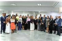 Grupo de pessoas posando para foto dentro de um auditório.