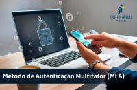 Foto das mãos de um homem mexendo no celular, em frente à um notebook que está sobre a mesa. Na base, texto escrito MÉTODO DE AUTENTICAÇÃO MULTIFATOR (MFA). No lado direito, na parte superior da imagem logomarca do TRT16.
